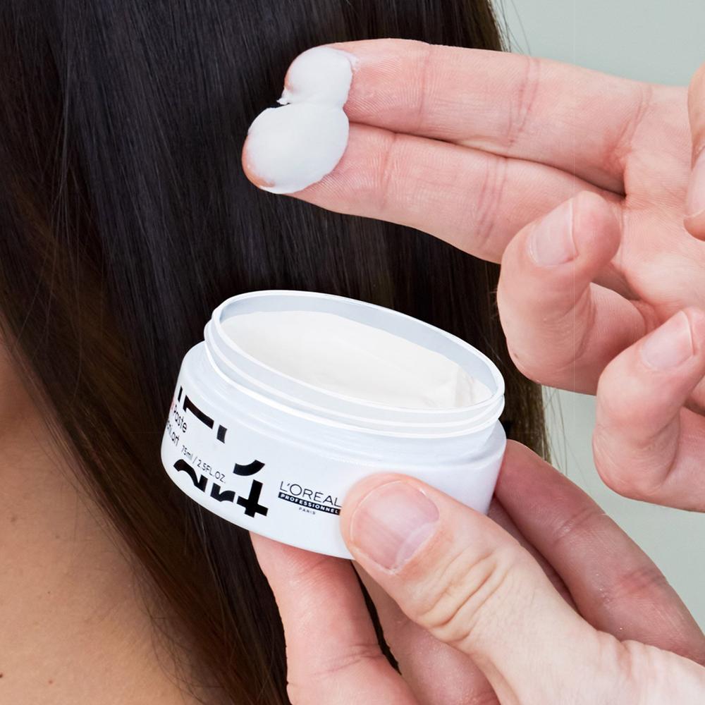 O cantitate mică de pastă mată pentru păr L'Oréal pe degete înainte de aplicare