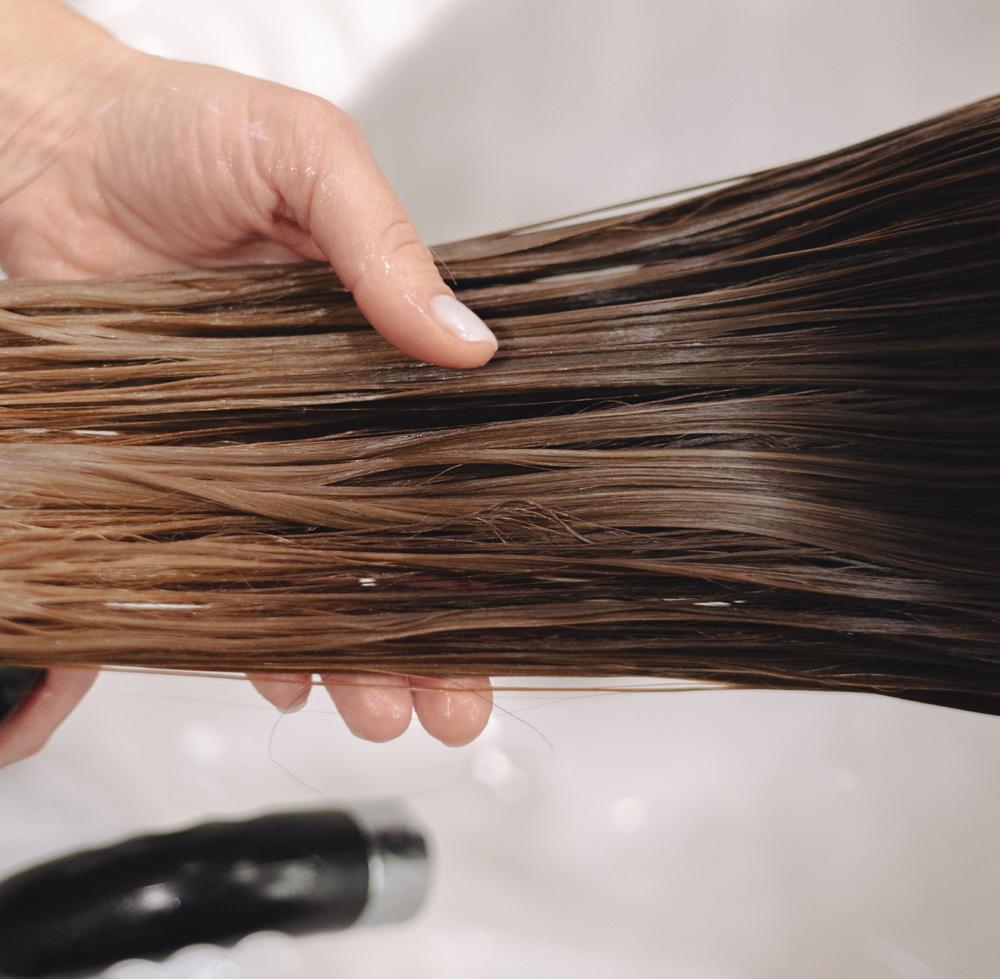 Păr brunet umed tratat cu balsam de păr