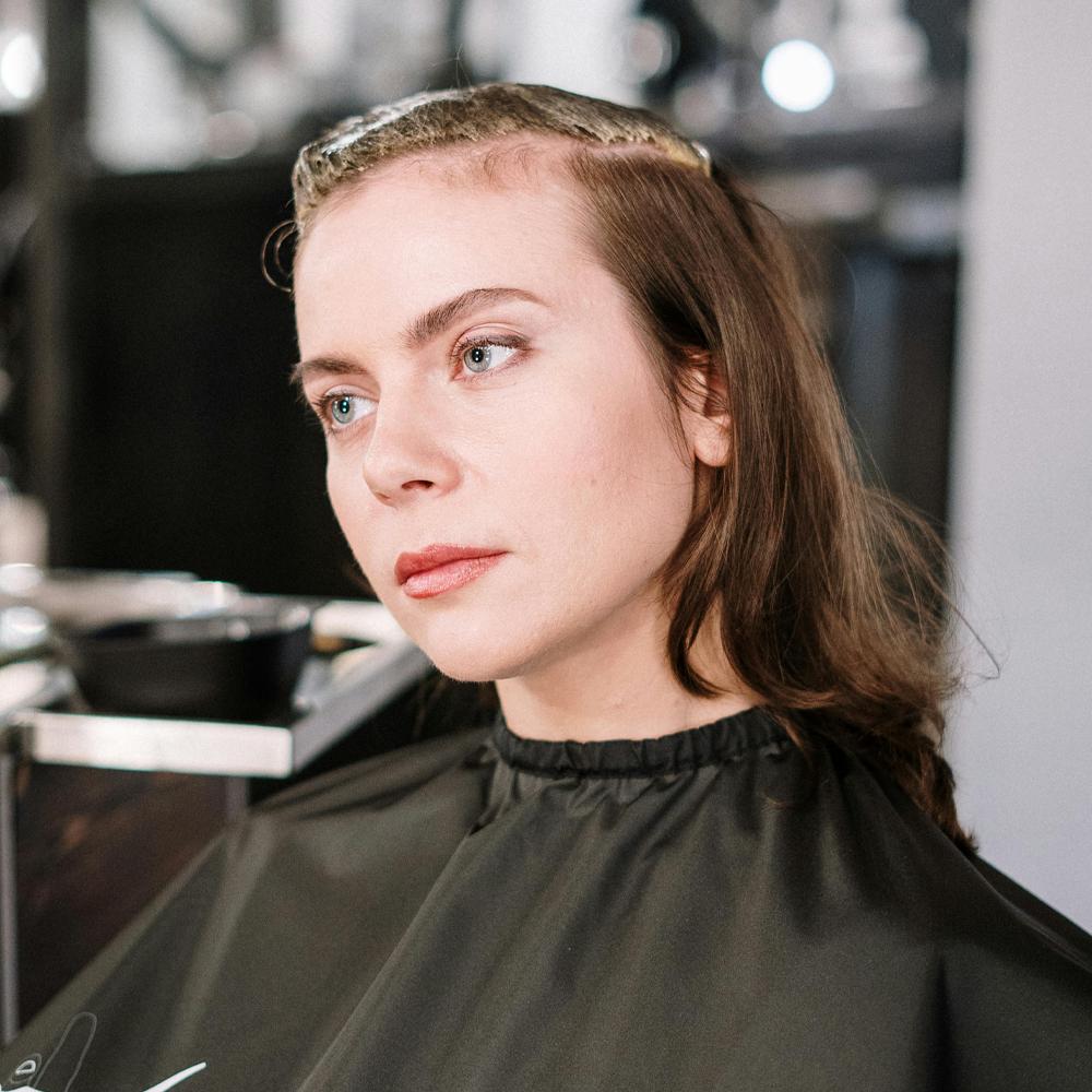 Femeie la coafor cu subțierea fină a părului la frunte